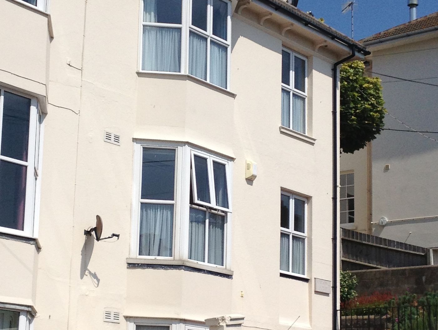Cream-painted terrace of flats with bay windows